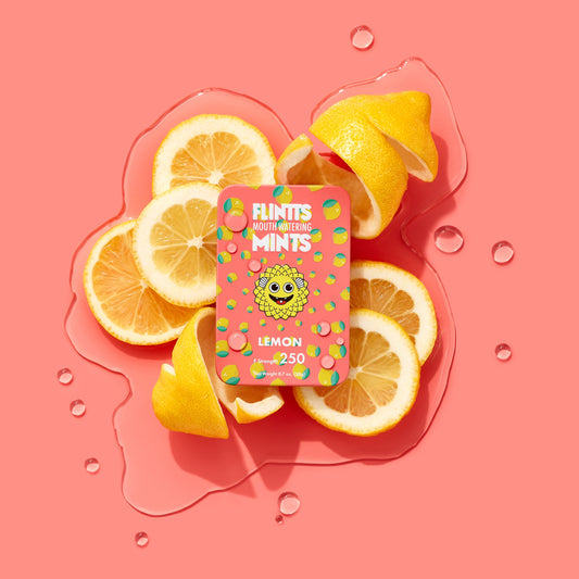 Flintts Mints Lemon F250 tin on lemon slices background – GetMints Australia